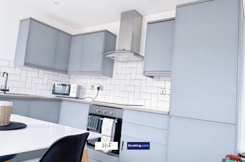 a kitchen with white cabinets and a white counter top at Luxury two bedroom apartment with parking games and fast unlimited Wi-Fi by Hush Haven Homes Serviced Accommodation in Hull