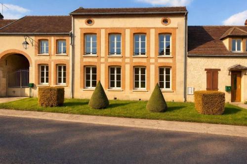 a large brick building with bushes in front of it at Gîte Famille Amis Jeux XXL Paris in Vauchamps