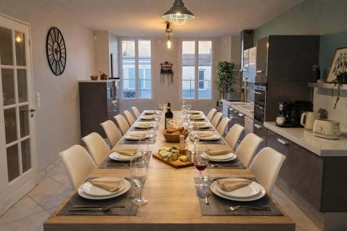 a long table with chairs and plates and wine glasses at Gîte Famille Amis Jeux XXL Paris in Vauchamps