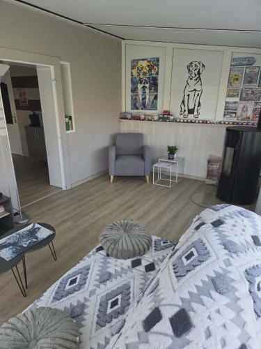 a bedroom with a bed and a couch and a chair at La maisonnette des Fontilles in Mauriac