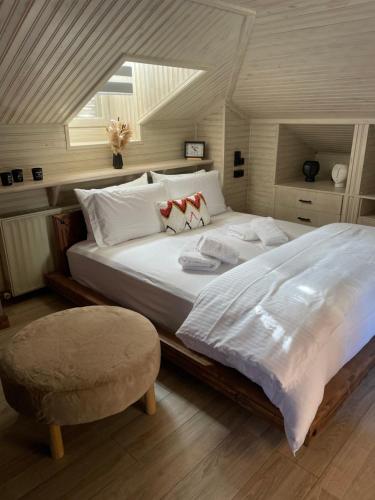a bedroom with a large white bed and a chair at Memories Apartments Μονοκατοικία στο Καρπενήσι in Karpenisi