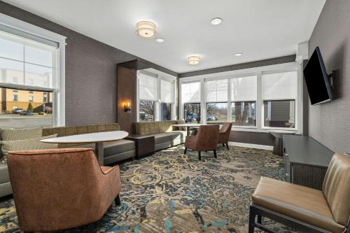 a waiting room with chairs and a table and windows at Residence Inn Paducah in Paducah