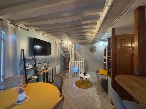 a living room with a yellow table and a staircase at Maison in Verneuil-en-Halatte