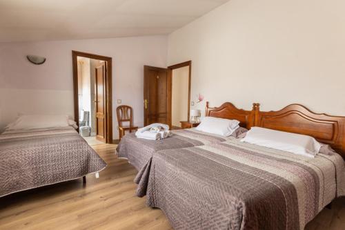 a bedroom with two beds and a wooden floor at Hostal La Balsá in La Alberca