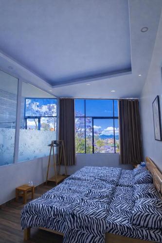 a large bed in a room with large windows at Salem House in Da Lat