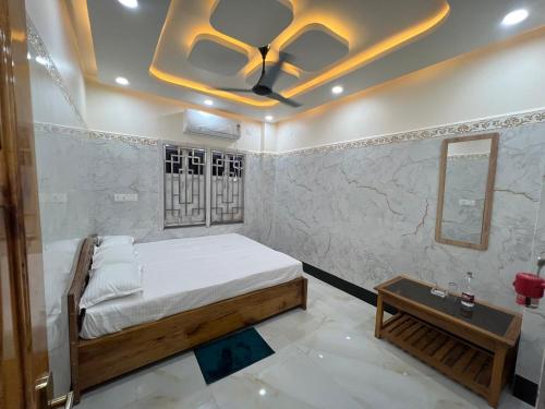 a bedroom with a bed and a ceiling fan at Jalangi Empire in mayapur