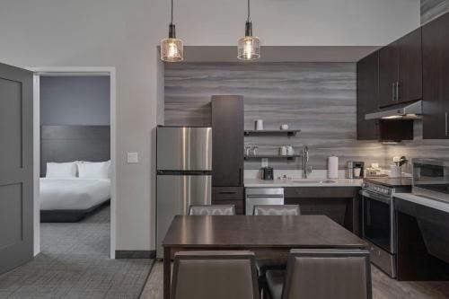 a kitchen with a table and a bed in a room at Residence Inn by Marriott Madison in Madison