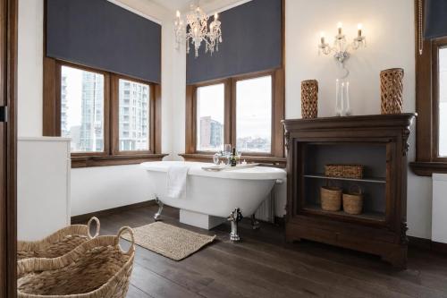 a bathroom with a tub and a sink and a chandelier at King's Inn City Hotel Alkmaar in Alkmaar