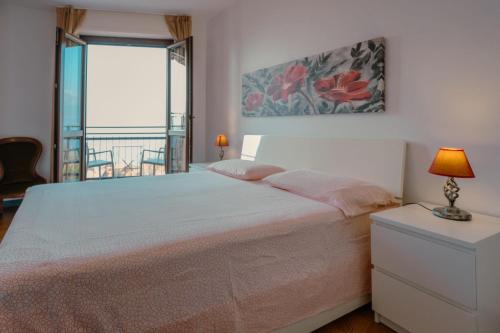 a bedroom with a bed and a balcony at House Carla in Bellano