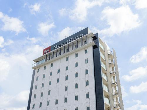 a white building with a sign on top of it at MyHotel Okazaki in Okazaki