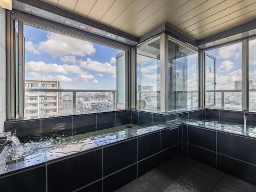 a large bathroom with a view of the city at MyHotel Okazaki in Okazaki
