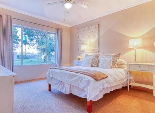 a bedroom with a large bed and a window at Riverside Rhapsody, Vaal River, Vanderbijlpark, 6 Adults and 4 Children in Vanderbijlpark