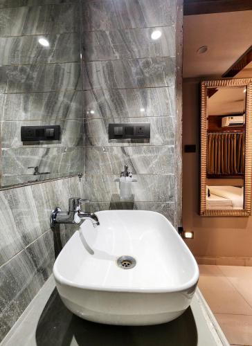 a bathroom with a white sink and a mirror at The Falcon Inn - Clare Road in Mumbai