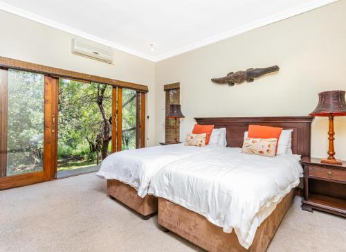 a bedroom with a large bed and a window at Elements Bush Villa 216 in Moheme