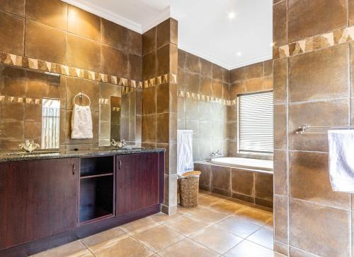 a large bathroom with a tub and a sink at Elements Bush Villa 216 in Moheme