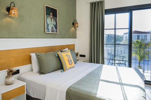 a bedroom with a large bed and a balcony at Lyse Jülide Hotel in Çeşme