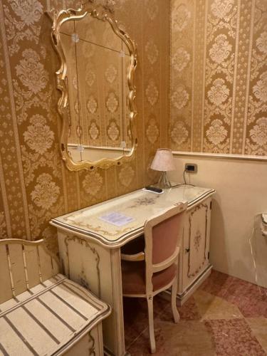 a dressing table with a lamp and a chair in a room at Hotel Diana in Venice