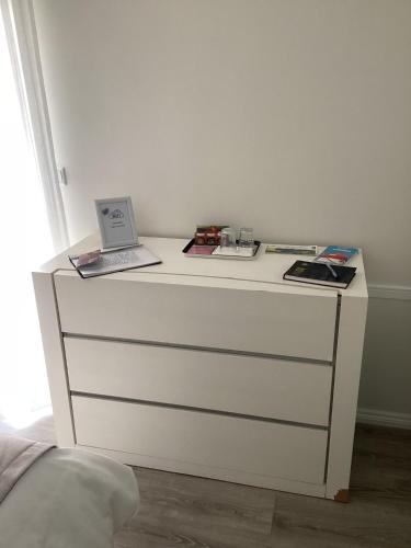 a white dresser with a laptop on top of it at Modern room (with deck) in Povoação