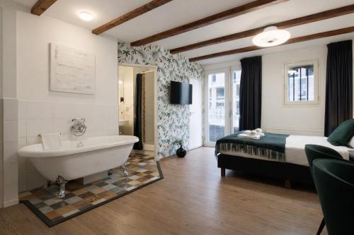 a bathroom with a bed and a bath tub and a bed and a tub at King's Inn City Hotel Alkmaar in Alkmaar