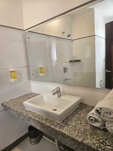 a bathroom with a sink and a mirror at Hotel Mayur by RoomsInc Katra in Katra