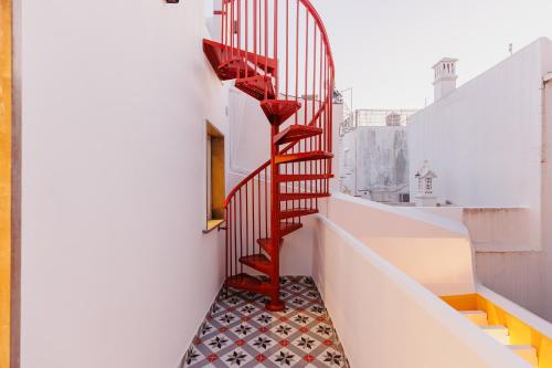 a stairway with a red stair case on a building at Laranjal Rive Gauche in Tavira