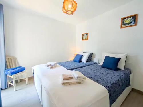two beds in a room with blue and white at Vilamoura Condo facing the pool by Algarve Dream Holidays in Quarteira