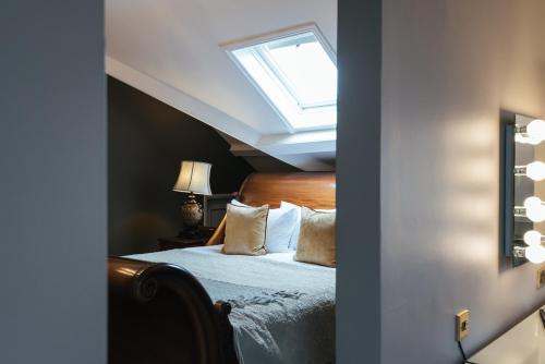 a bedroom with a bed with a skylight at The Spa Hotel in Royal Tunbridge Wells