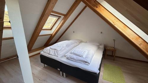 a bedroom with a bed in the attic at Válur Cozy Cottage in Válur
