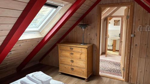 a attic room with a dresser and a window at Válur Cozy Cottage in Válur