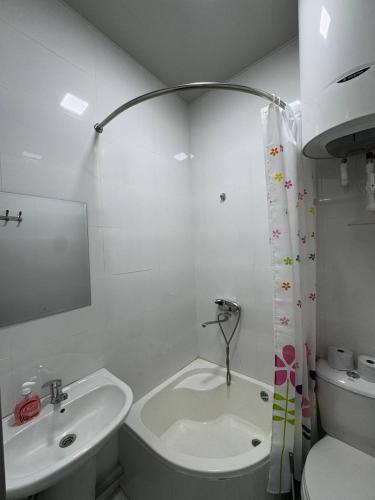 a white bathroom with a sink and a toilet and a sink at SumayShakh Guest House in Bukhara