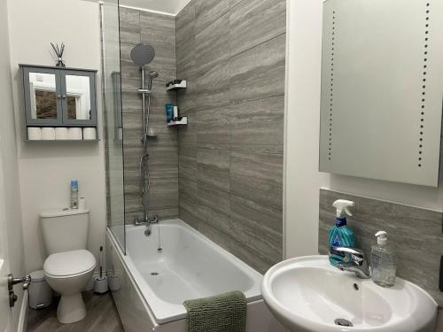a bathroom with a tub and a sink and a toilet at 2 bed house sleeps 4 centre of Welshpool Parking in Welshpool