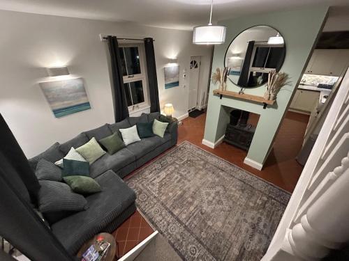 a living room with a couch and a mirror at 2 bed house sleeps 4 centre of Welshpool Parking in Welshpool