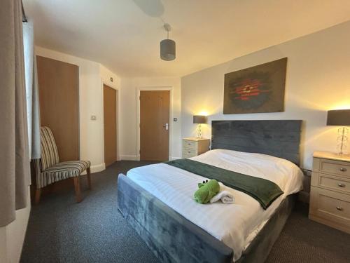 a bedroom with a bed with a stuffed animal on it at Spacious 2 Bed 2 Shower Apartment in Crewe