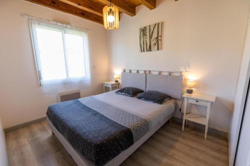 un dormitorio con una cama grande y dos ventanas en Juine, en Fargues