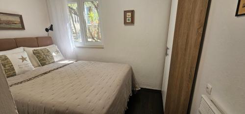 a bedroom with a bed in a room with a window at Apartment MiriMore in Hodilje