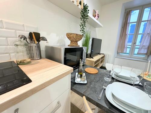a kitchen with a counter with a sink and a microwave at Le Cabrol Hyper centre WIFI 1er étage in Rodez
