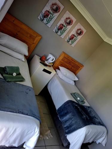 a bedroom with two beds and paintings on the wall at Lodge Linga Longa in Queenstown