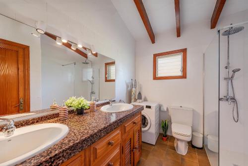 a bathroom with two sinks and a toilet at Villa Can Deyá in Port de Pollensa