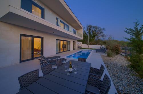 a villa with a swimming pool and a house at Villa Sensei in Linardići