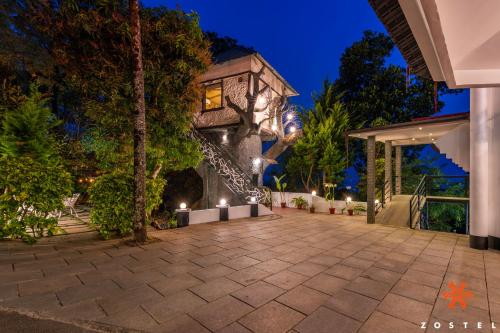 a patio in front of a house at night at Zostel Munnar in Devikolam