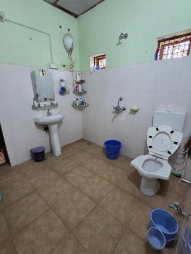 a bathroom with a toilet and a sink at Commander's Home in Kangra
