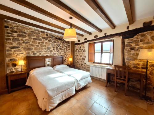 a bedroom with a large bed in a stone wall at Oceano verde in Cervera de Pisuerga