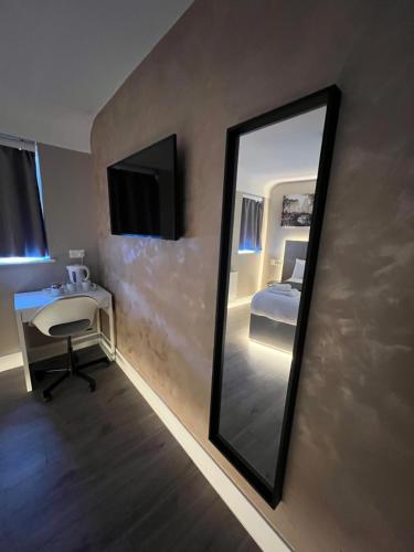 a mirror in a room with a bed and a desk at Rest Inn Edmonton in Edmonton