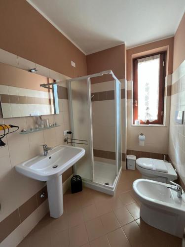 a bathroom with a sink and a shower and a toilet at House IL CORALLO in Castrezatto