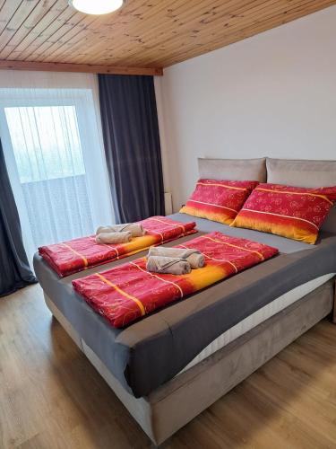 a large bed in a room with red and orange pillows at Ferienwohnung Sankt Josef 2 in Bodensdorf