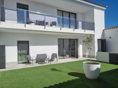 a white house with a yard with a potted plant at Apartamentos EL FONTANAR in Almagro