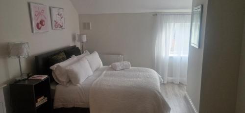 a bedroom with a bed with white sheets and a window at Banbury causeway in Banbury