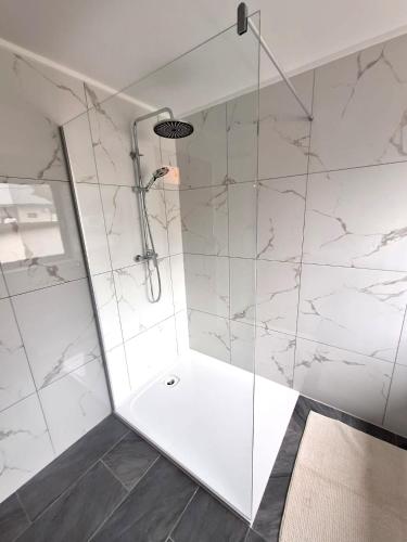 a bathroom with a shower with white marble walls at Ferienwohnung Sankt Josef 2 in Bodensdorf