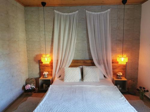 a bedroom with a bed with curtains and two lamps at Kefalonia Olive House private pool in Xi
