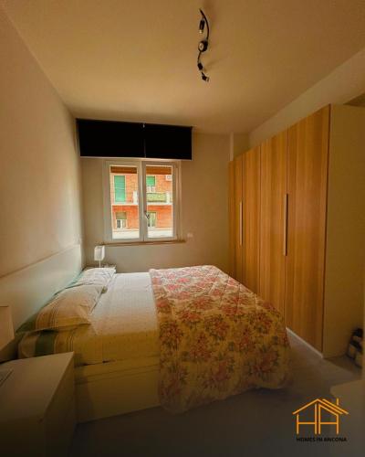 a bedroom with a bed and a window at CarloAlberto23- Rooms by Homes in Ancona in Ancona